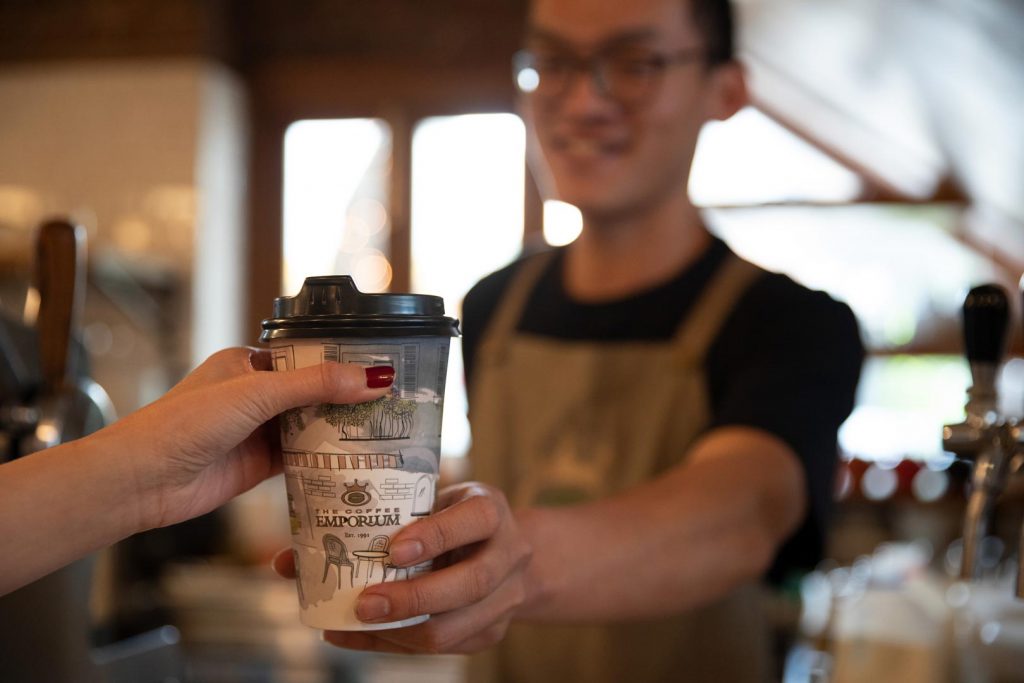 Barista serving a takeaway coffee